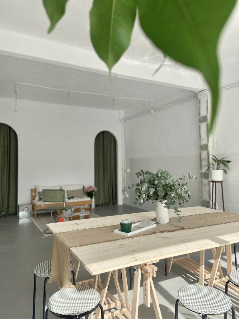 Sala de talleres y eventos de .PATIO Burgos, mesa de madera y plantas